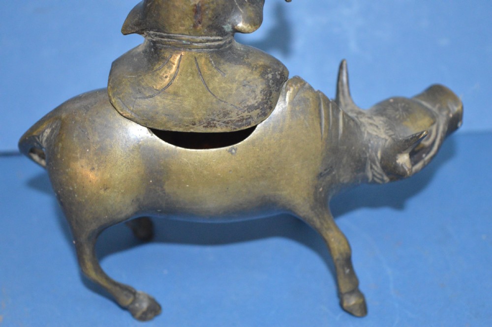 A late 19th-century cast bronze censer depicting a man dressed in robes seated astride a horned ox or water buffalo. View VIII