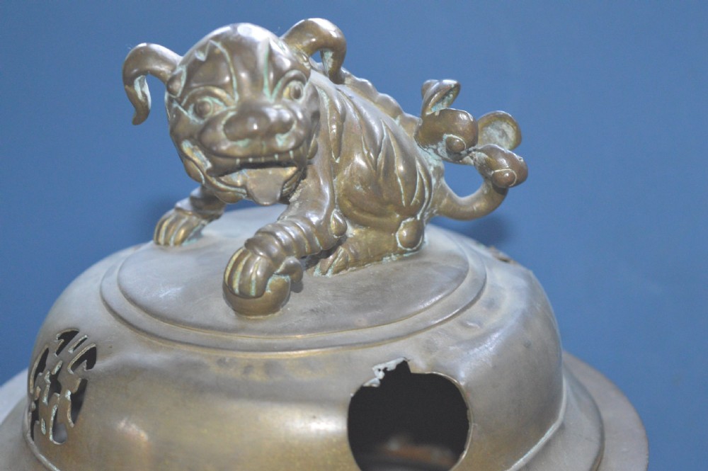 A heavy Chinese bronze lidded censer featuring a foo dog lid finial, pierced cover, double beast side handles, and three tripod feet. View III