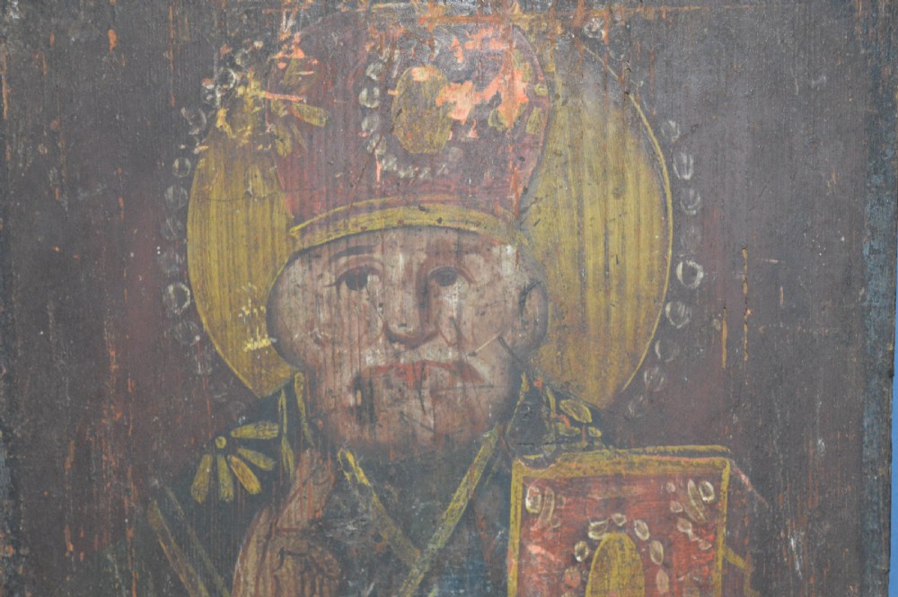 An antique hand-painted Russian wooden icon depicting a religious figure with a halo and holding a scripture book. View II