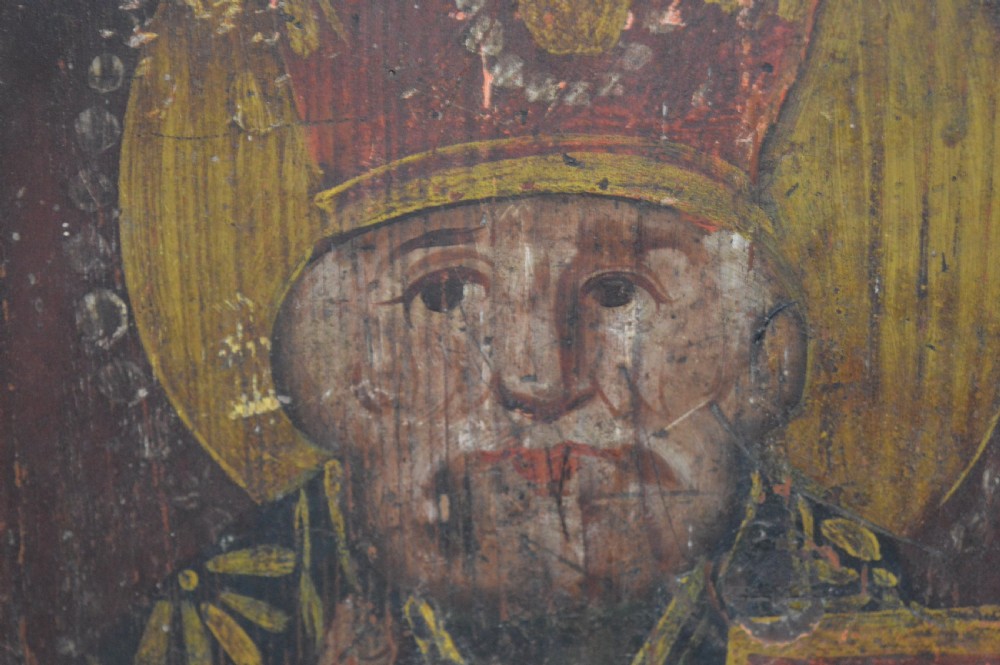 An antique hand-painted Russian wooden icon depicting a religious figure with a halo and holding a scripture book. View V