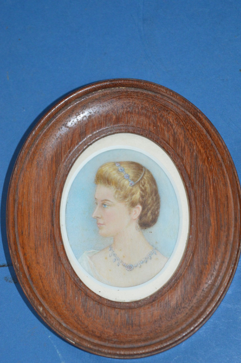 A pair of late 19th-century oval miniature watercolour portraits depicting a woman and a man in matching moulded wooden frames. View III