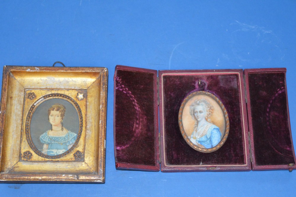 Two Georgian portrait miniatures from circa 1800, one set in a rectangular giltwood frame and the other in a velvet-lined burgundy leather folding case.