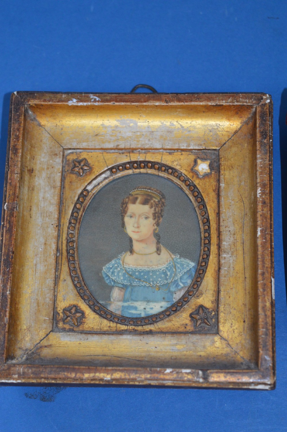 Two Georgian portrait miniatures from circa 1800, one set in a rectangular giltwood frame and the other in a velvet-lined burgundy leather folding case. View III