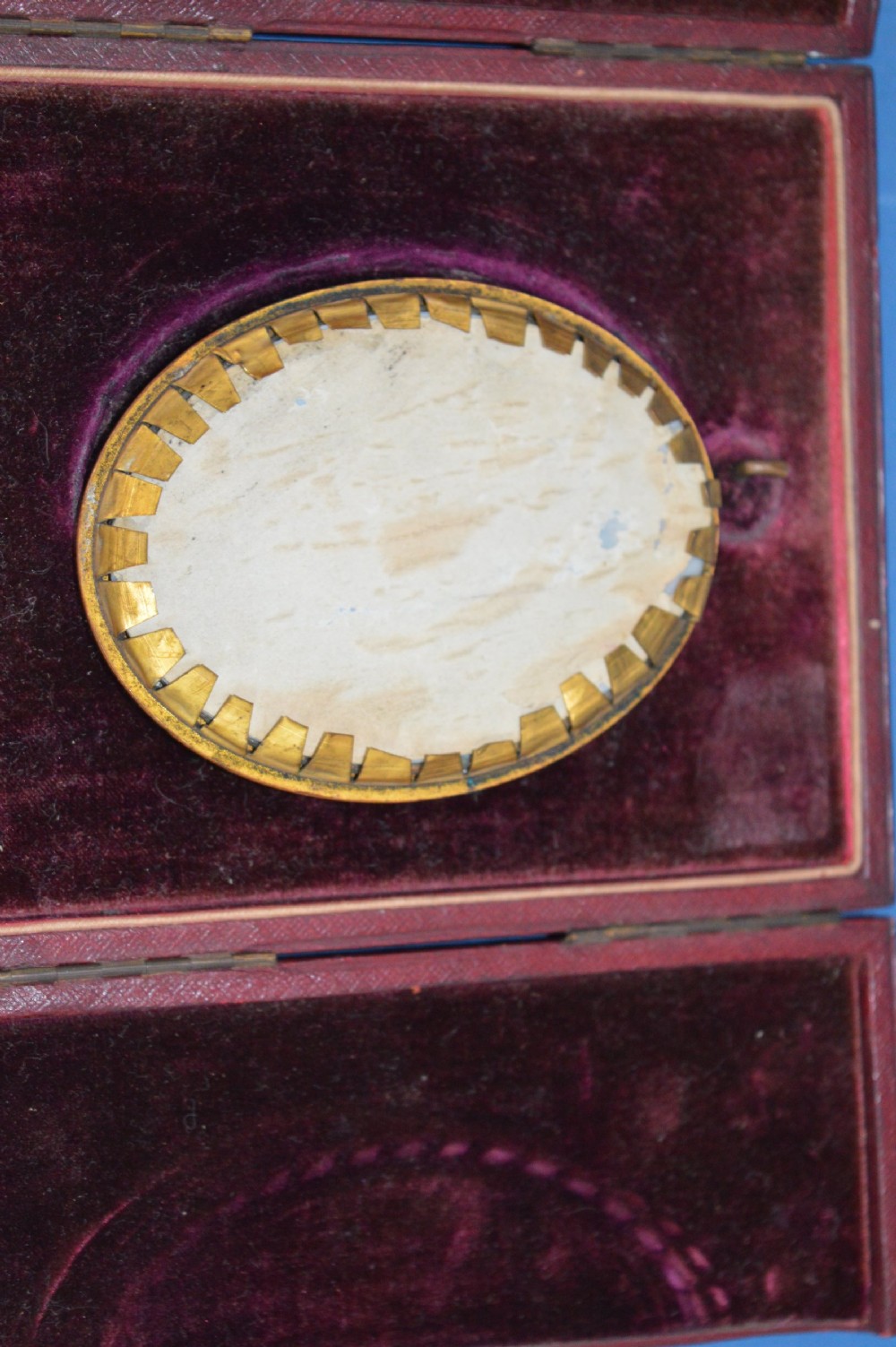 Two Georgian portrait miniatures from circa 1800, one set in a rectangular giltwood frame and the other in a velvet-lined burgundy leather folding case. View V