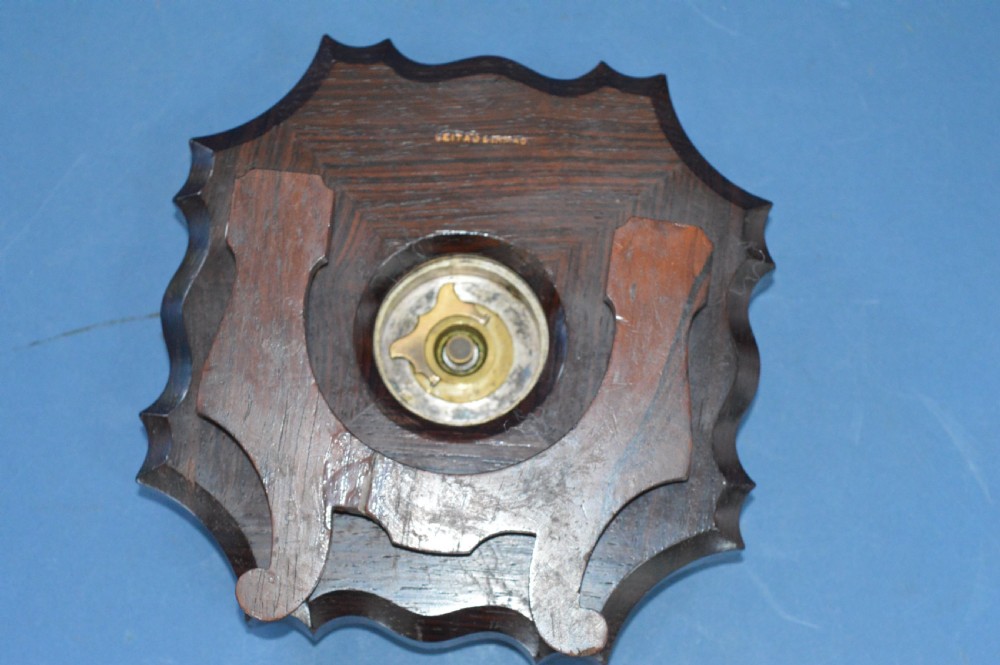 An Art Nouveau shaped wooden mantel clock clad in ornate chased silver relief with foliage motifs surrounding a central white enamel dial. View VIII