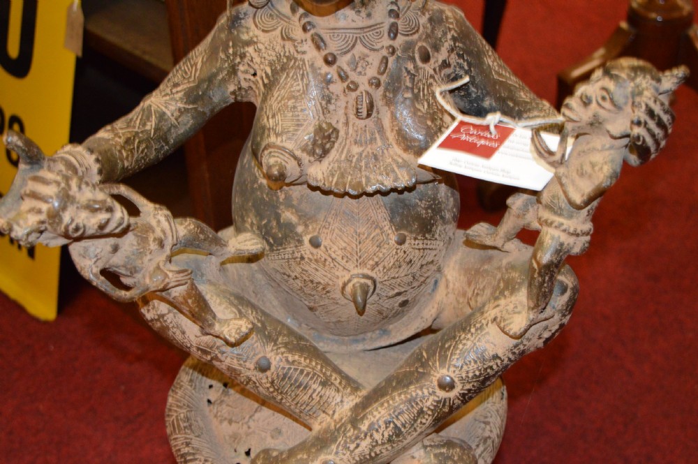 A cast bronze West African maternity statue depicting a seated female figure with elaborate headwear and detailed surface carving holding two smaller child figures. View IV