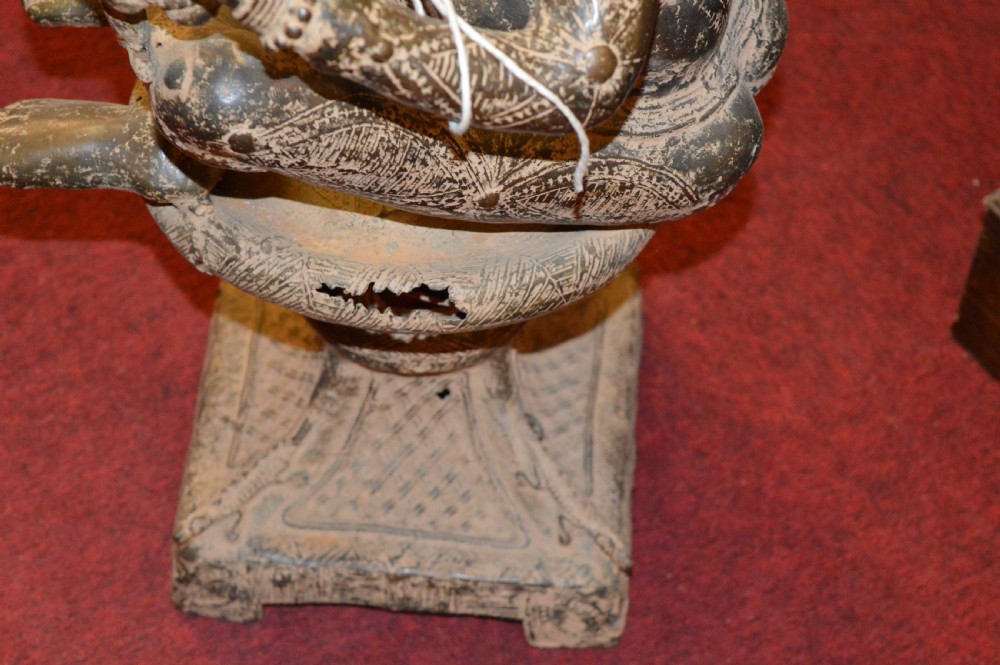 A cast bronze West African maternity statue depicting a seated female figure with elaborate headwear and detailed surface carving holding two smaller child figures. View IX