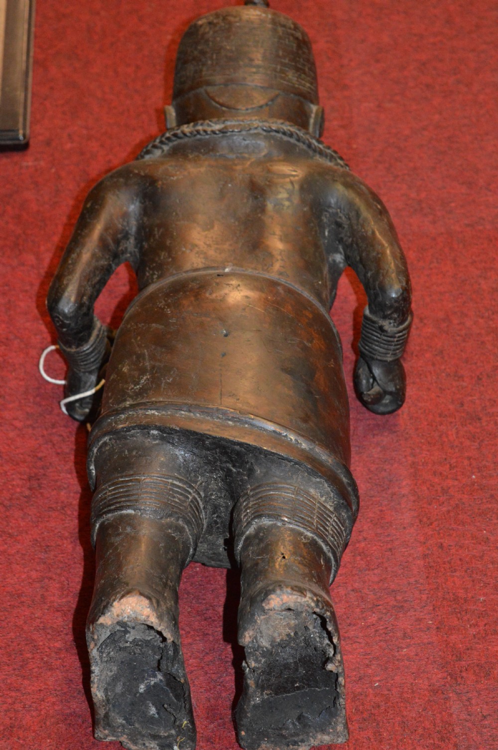 A standing cast bronze West African warrior figure with ceremonial headwear, detailed chest ornamentation, and traditional waist garment. View II
