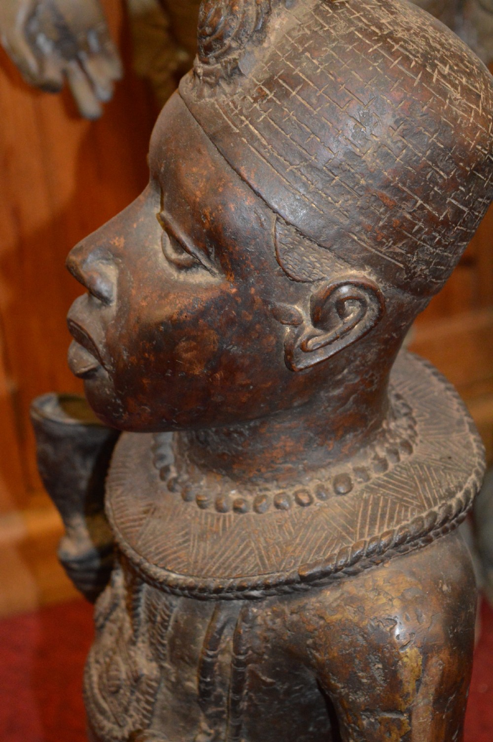 A standing cast bronze West African warrior figure with ceremonial headwear, detailed chest ornamentation, and traditional waist garment. View XIII