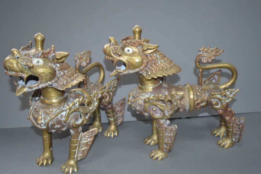 A pair of 19th-century cast bronze Tibetan temple lions featuring stylized wings, open jaws, and original patinated surface. View IV