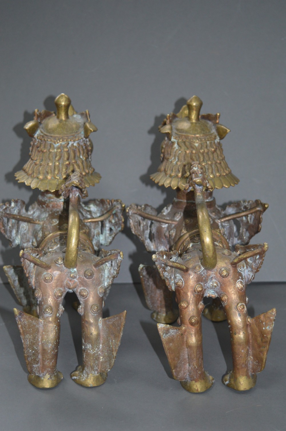 A pair of 19th-century cast bronze Tibetan temple lions featuring stylized wings, open jaws, and original patinated surface. View VIII
