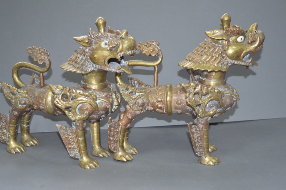 A pair of 19th-century cast bronze Tibetan temple lions featuring stylized wings, open jaws, and original patinated surface. View XI