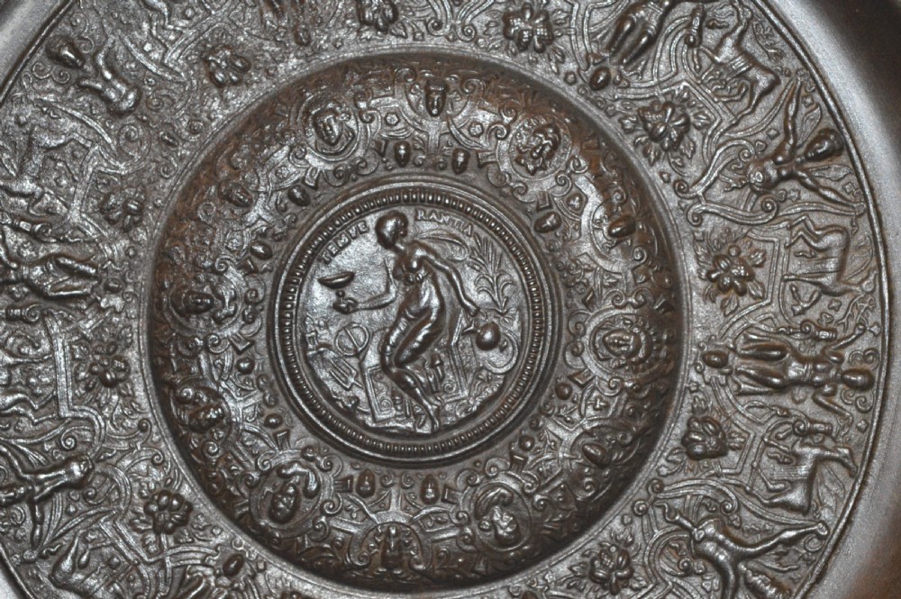 A large circular dark bronze charger featuring concentric bands of classical relief figures surrounding a central classical medallion. View IV