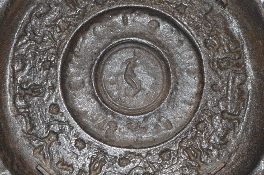 A large circular dark bronze charger featuring concentric bands of classical relief figures surrounding a central classical medallion. View X