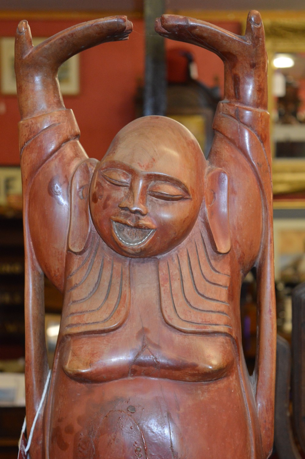 A nineteenth-century carved wooden statue depicting a laughing Buddha figure standing with arms raised above its head. View II