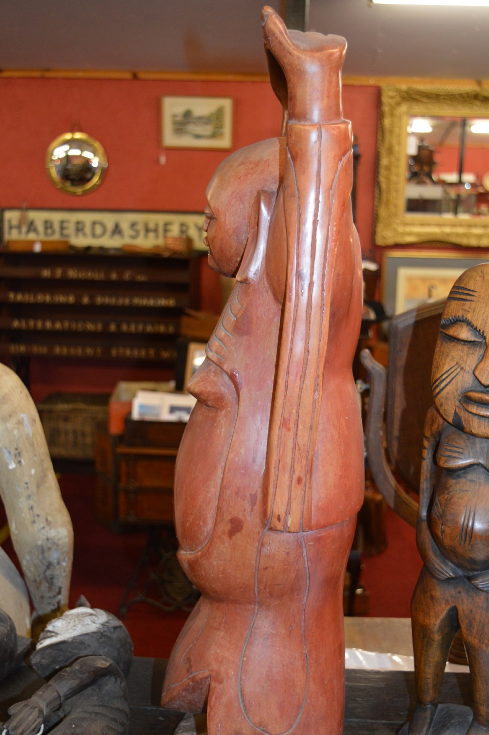A nineteenth-century carved wooden statue depicting a laughing Buddha figure standing with arms raised above its head. View VII