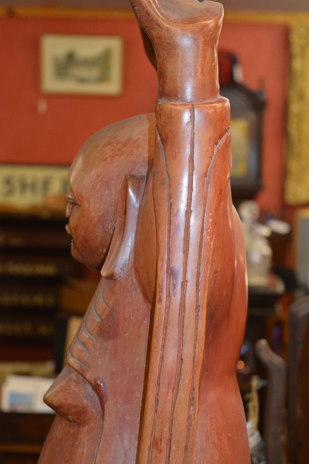 A nineteenth-century carved wooden statue depicting a laughing Buddha figure standing with arms raised above its head. View VIII