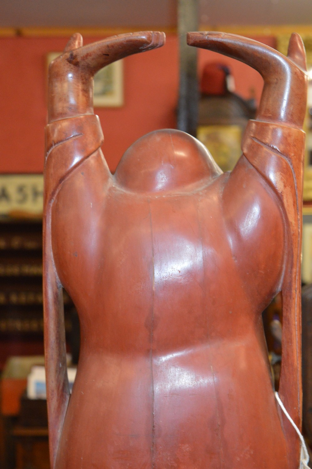 A nineteenth-century carved wooden statue depicting a laughing Buddha figure standing with arms raised above its head. View IX