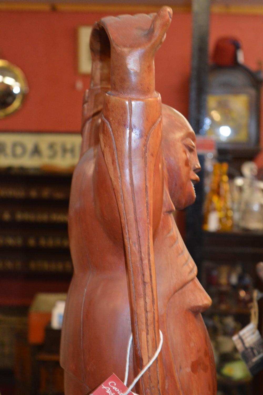 A nineteenth-century carved wooden statue depicting a laughing Buddha figure standing with arms raised above its head. View XI