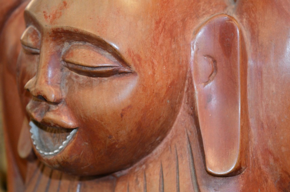 A nineteenth-century carved wooden statue depicting a laughing Buddha figure standing with arms raised above its head. View XIV