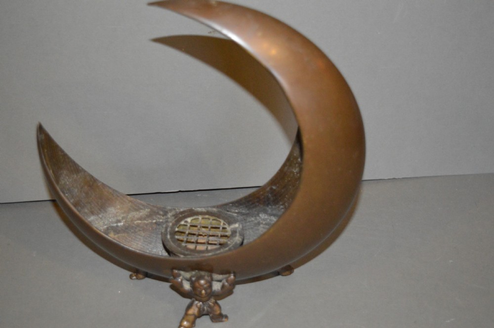 A bronze incense burner crafted in a crescent moon shape with figural supports and a central removable grate. View V