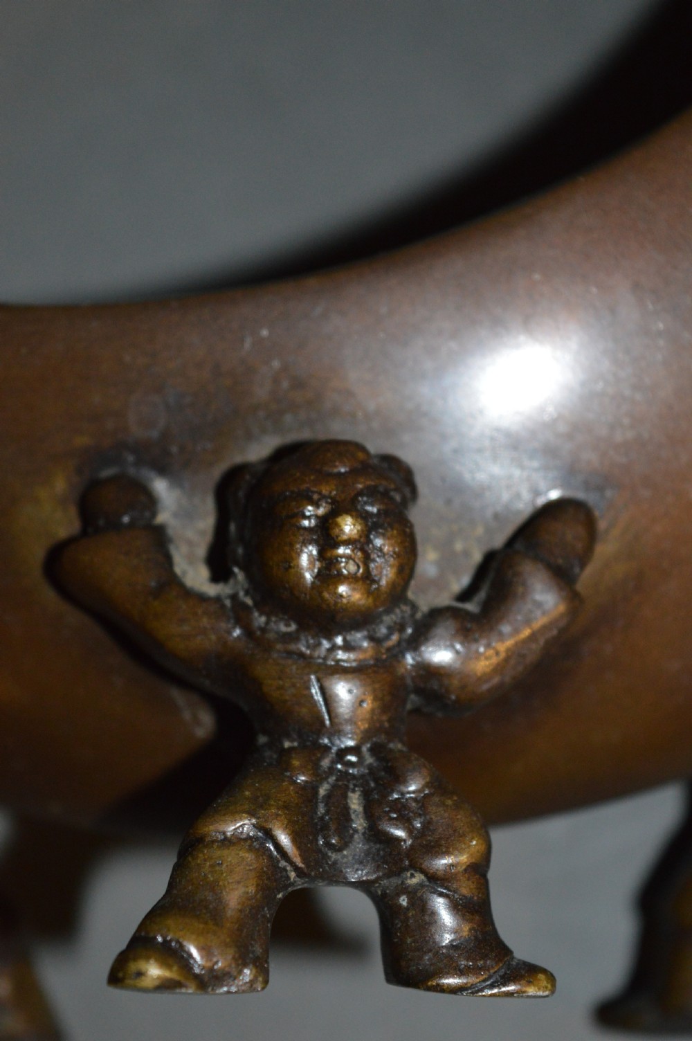 A bronze incense burner crafted in a crescent moon shape with figural supports and a central removable grate. View VIII