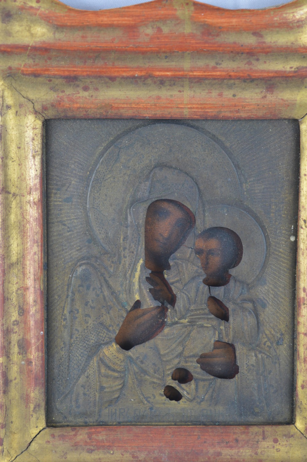 An early 20th-century Russian Orthodox icon depicting the Virgin Mary and Christ Child inside a carved, gilded wooden frame. View II