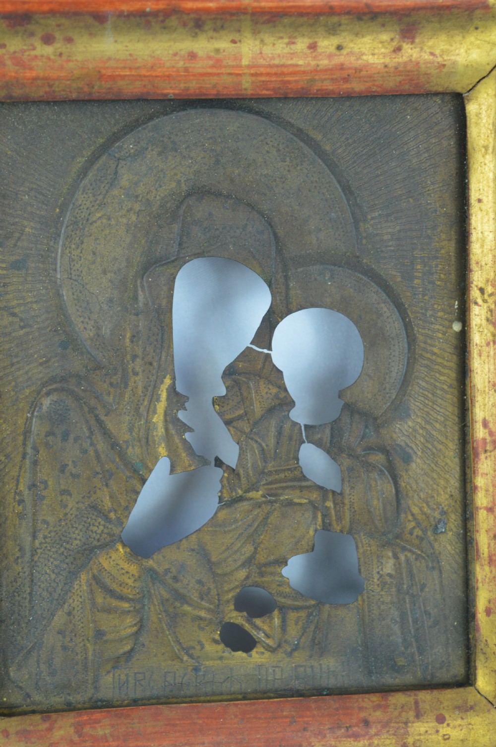 An early 20th-century Russian Orthodox icon depicting the Virgin Mary and Christ Child inside a carved, gilded wooden frame. View V