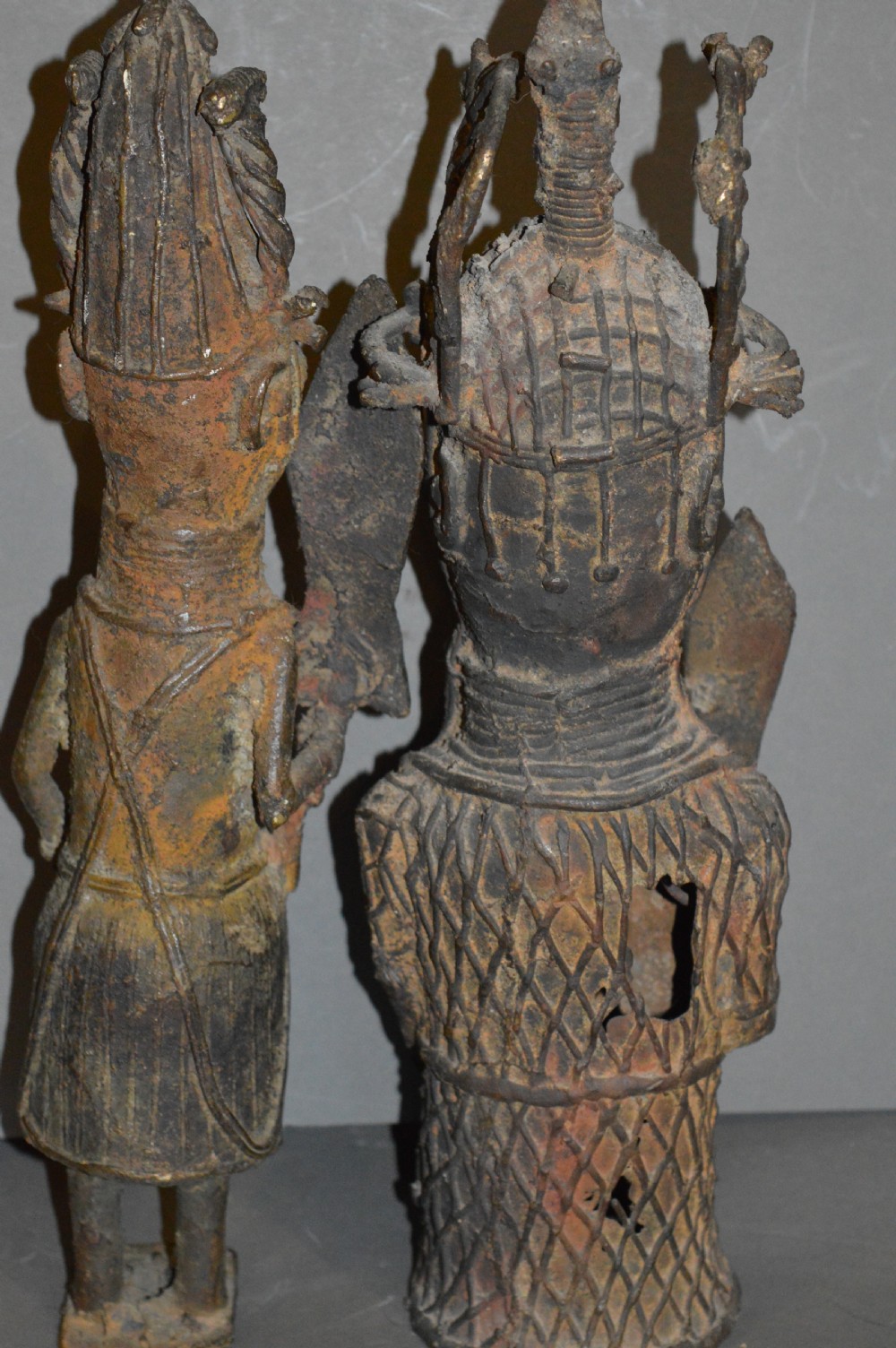 A pair of cast bronze West African warrior statues featuring textured headpieces, patterned garments, and held spears. View VI