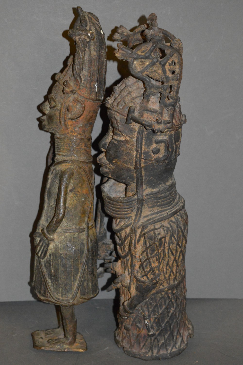 A pair of cast bronze West African warrior statues featuring textured headpieces, patterned garments, and held spears. View VIII