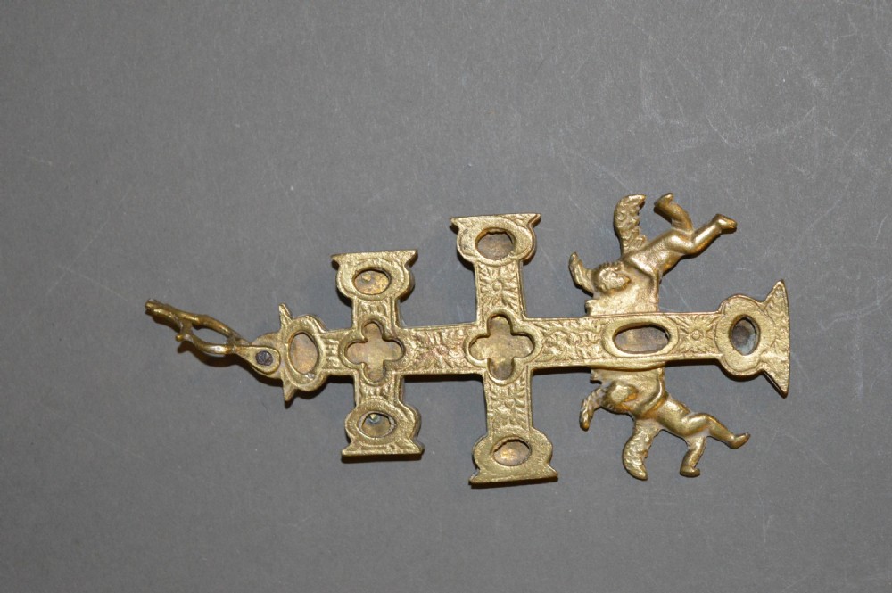 A set of three late nineteenth-century Spanish brass devotional items, including two Caravaca double-barred crosses with angel figures and one central hinged miniature shrine. View V