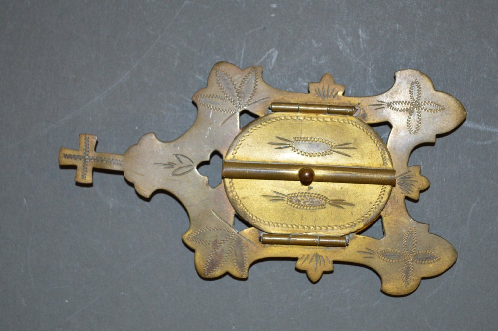 A set of three late nineteenth-century Spanish brass devotional items, including two Caravaca double-barred crosses with angel figures and one central hinged miniature shrine. View X