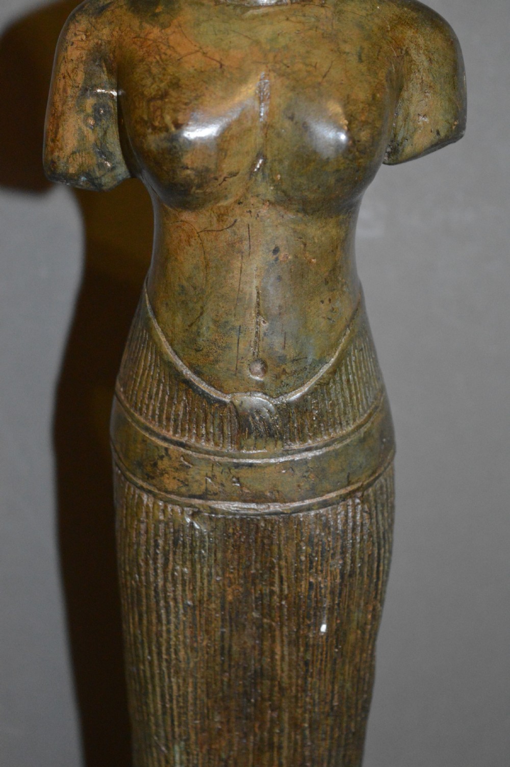 A standing patinated bronze figure of a Buddhist deity mounted on a turned wooden socle base. View V