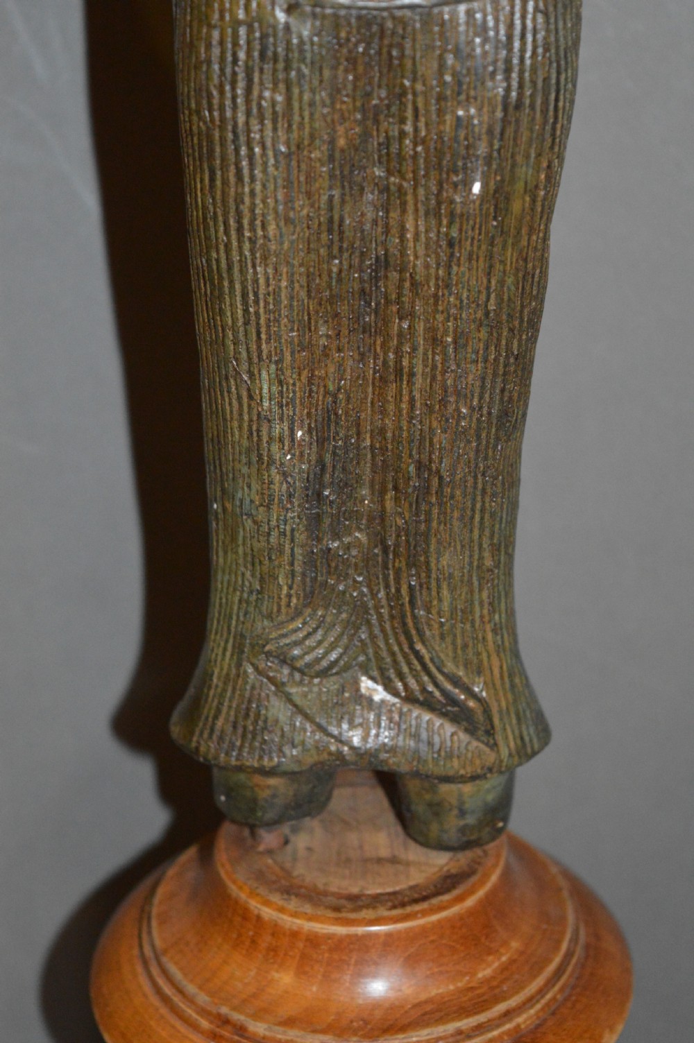 A standing patinated bronze figure of a Buddhist deity mounted on a turned wooden socle base. View VI
