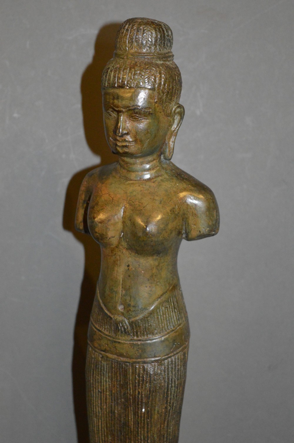 A standing patinated bronze figure of a Buddhist deity mounted on a turned wooden socle base. View XIII