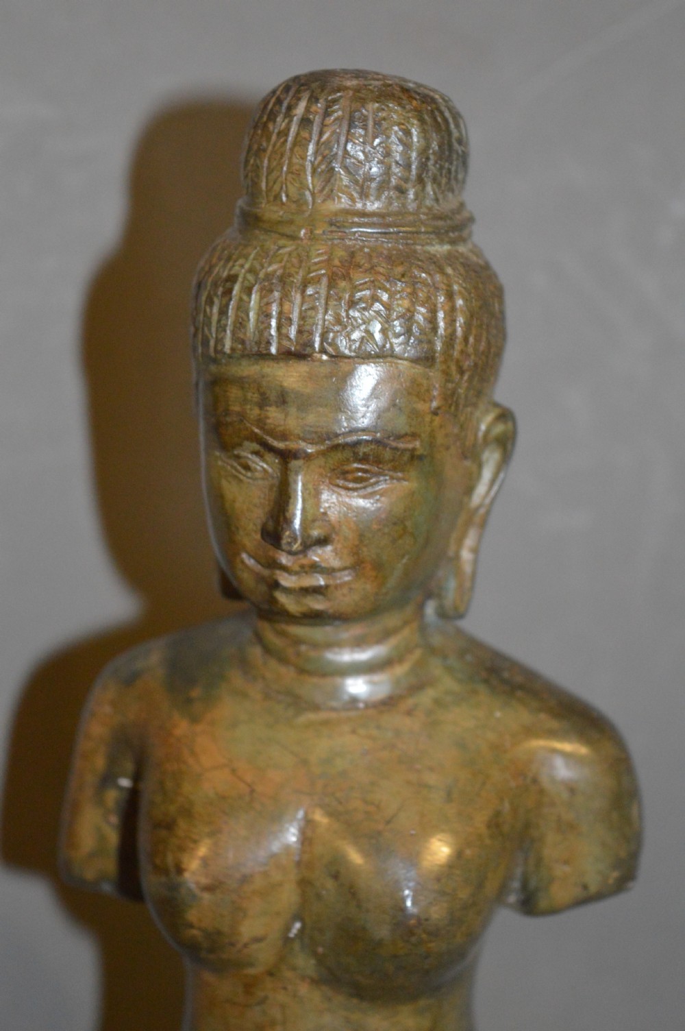 A standing patinated bronze figure of a Buddhist deity mounted on a turned wooden socle base. View XIV