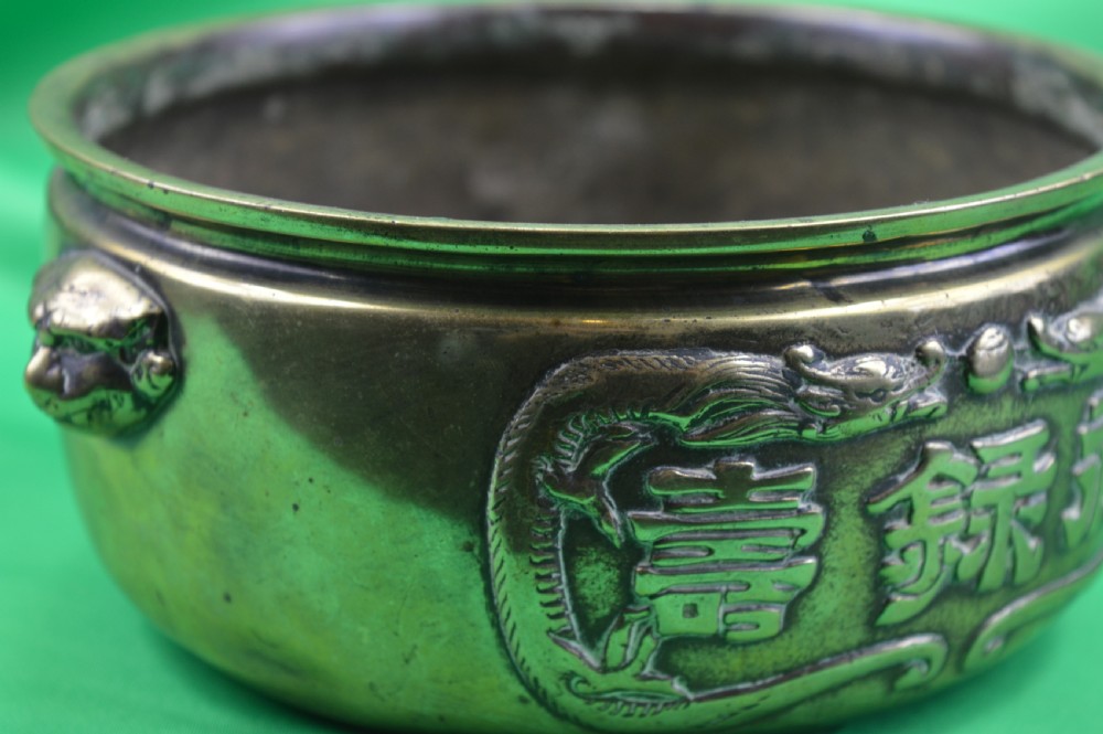 A late 19th-century Chinese cast bronze incense censer featuring raised relief Chinese character panels and side handles formed as lion masks. View V