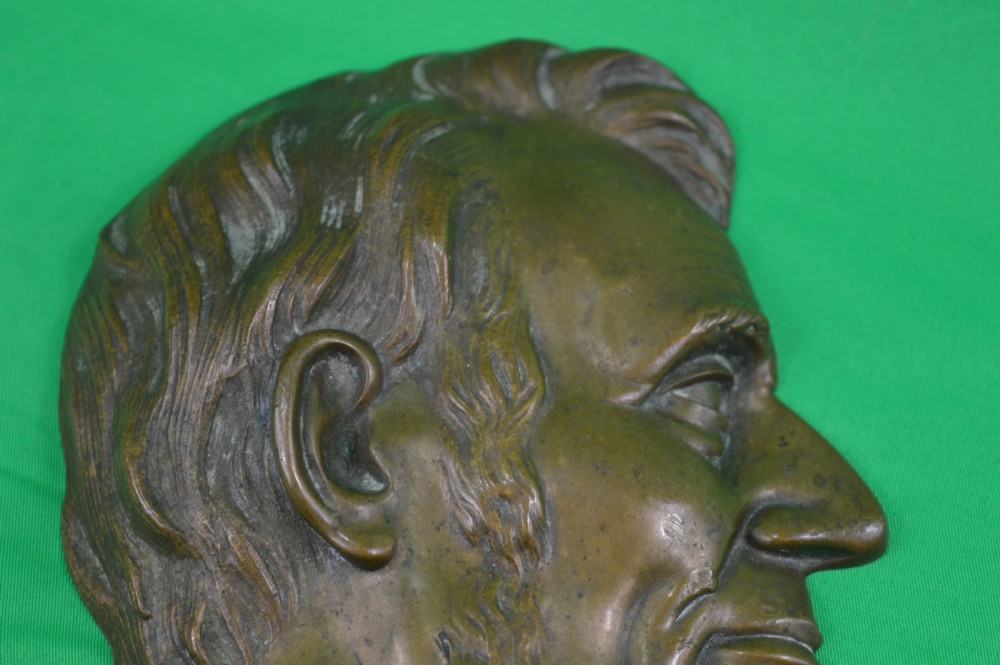 A cast bronze relief profile plaque depicting Abraham Lincoln in right-facing profile with a patinated dark brown surface. View III