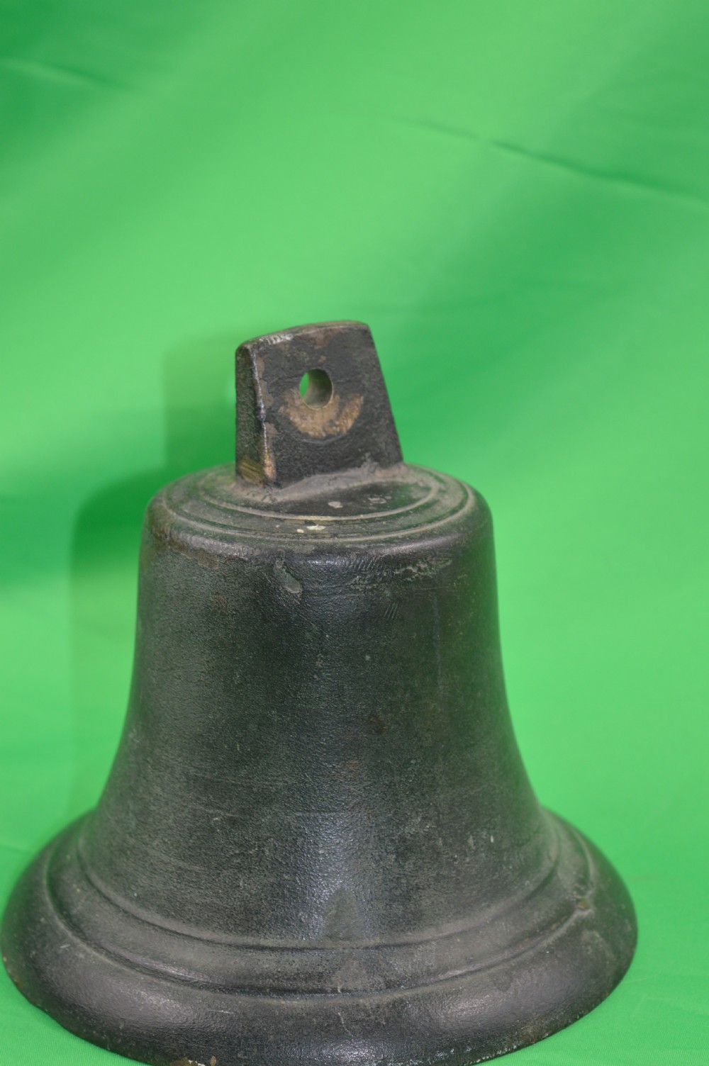 A nineteenth-century cast bronze ships bell featuring a dark aged patina, subtle molded body ring detailing, and an upper mounting lug.