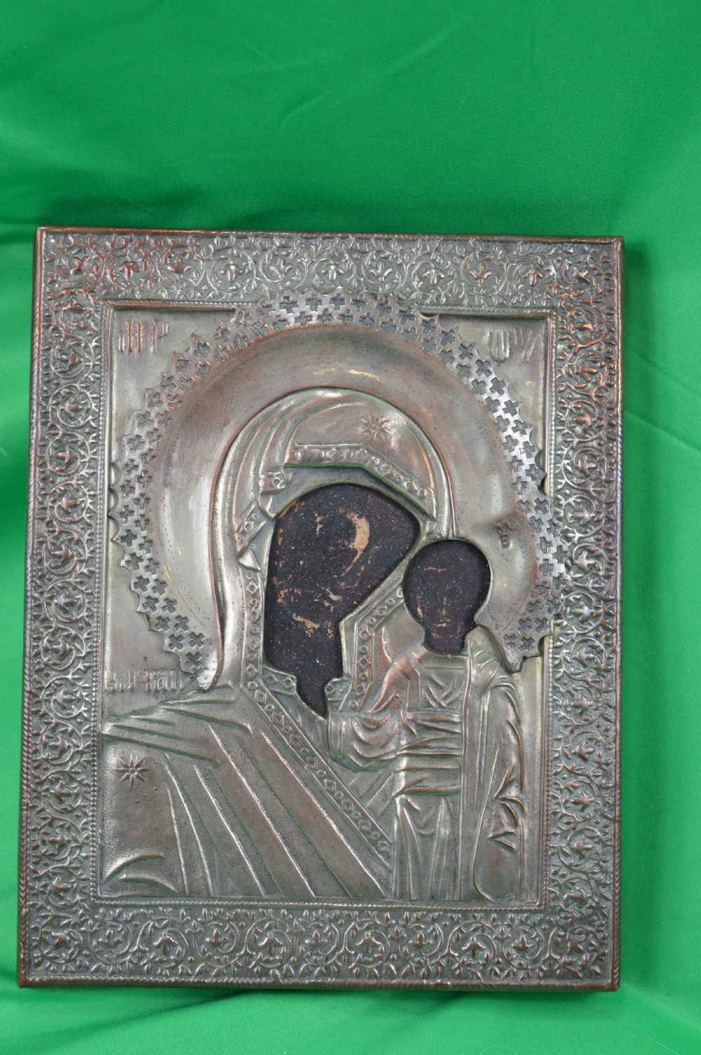 A late nineteenth-century Russian Orthodox icon depicting the Virgin Mary and Child beneath a chased metal oklad cover.