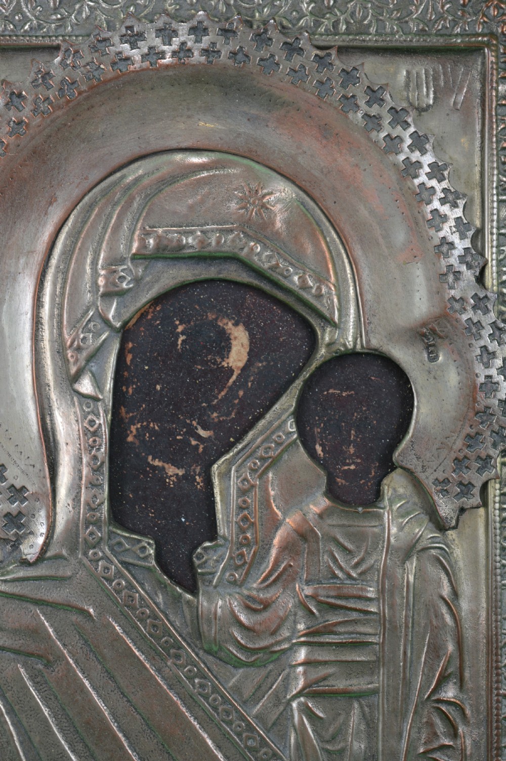 A late nineteenth-century Russian Orthodox icon depicting the Virgin Mary and Child beneath a chased metal oklad cover. View II