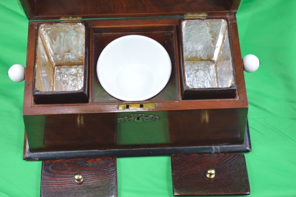 A Regency mahogany tea caddy featuring a tapered sarcophagus shape, stepped hinged lid, and central brass keyhole escutcheon. View IV
