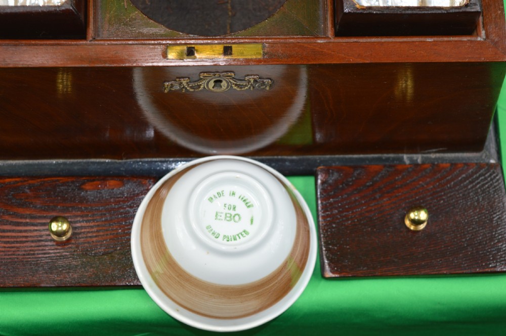 A Regency mahogany tea caddy featuring a tapered sarcophagus shape, stepped hinged lid, and central brass keyhole escutcheon. View VI