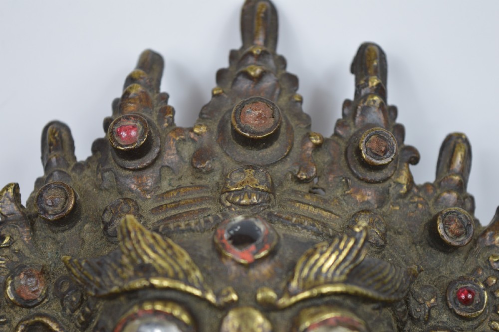 A late 19th-century Tibetan cast bronze incense burner depicting the wrathful deity Mahakala with open mouth and glass inlays. View III