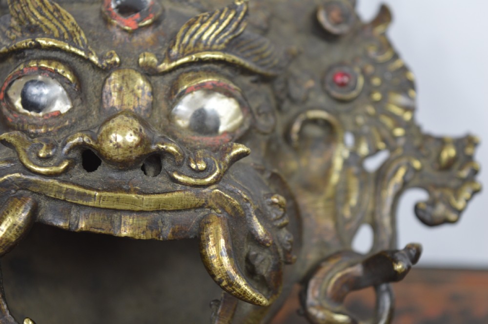 A late 19th-century Tibetan cast bronze incense burner depicting the wrathful deity Mahakala with open mouth and glass inlays. View IV
