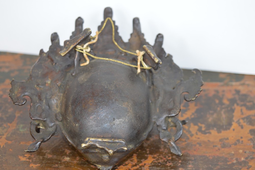 A late 19th-century Tibetan cast bronze incense burner depicting the wrathful deity Mahakala with open mouth and glass inlays. View VI
