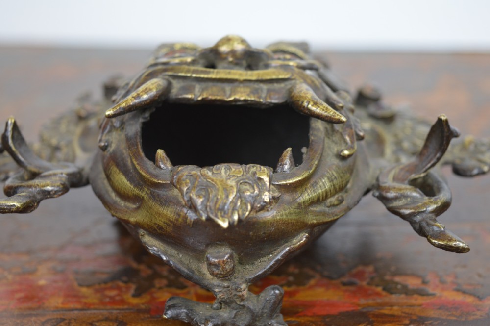 A late 19th-century Tibetan cast bronze incense burner depicting the wrathful deity Mahakala with open mouth and glass inlays. View VII
