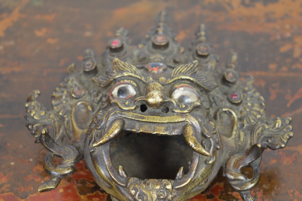 A late 19th-century Tibetan cast bronze incense burner depicting the wrathful deity Mahakala with open mouth and glass inlays. View VIII