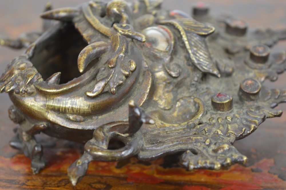A late 19th-century Tibetan cast bronze incense burner depicting the wrathful deity Mahakala with open mouth and glass inlays. View IX