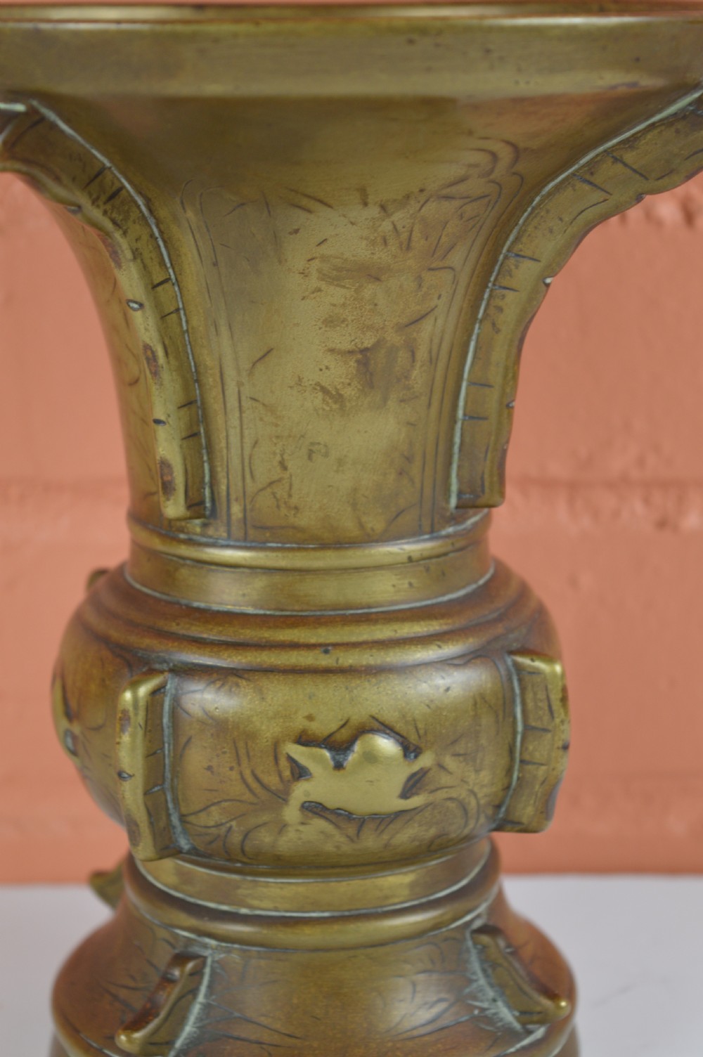 A cast bronze trumpet-shaped Chinese Gu vase with vertical flanges, a bulbous central section, and incised archaic pattern detailing. View II